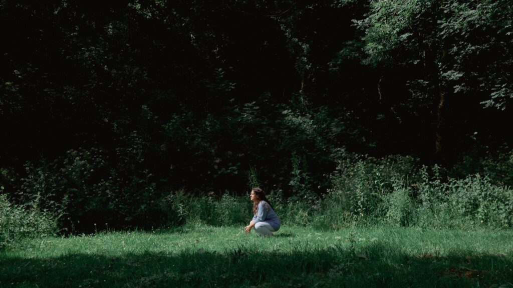 Andrea Guitérrez Psicoterapeuta en un bosque entre flores